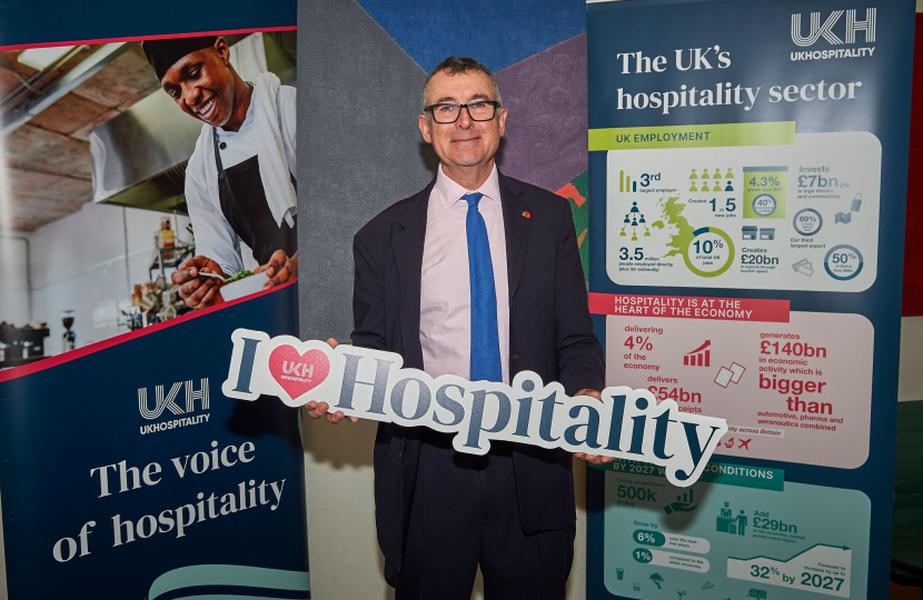 Bernard holding a "I love hospitality" sign 