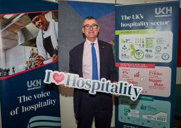 Bernard holding a "I love hospitality" sign 